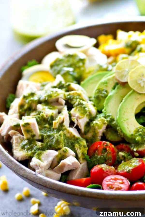 Vibrant Green Goddess Cobb 2 A vibrant, fresh Green Goddess Summer Cobb Salad, overflowing with colorful summer vegetables, grilled chicken, hard-boiled eggs, avocado, and crumbled feta cheese, drizzled with a rich basil green goddess dressing.