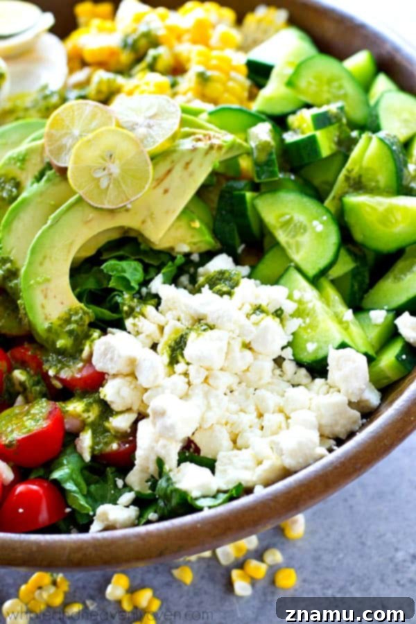 Vibrant Green Goddess Cobb 3 Close-up shot of the Green Goddess Summer Cobb Salad, showcasing the finely chopped ingredients like romaine lettuce, cherry tomatoes, corn, and chicken, with a generous drizzle of the vibrant green dressing.