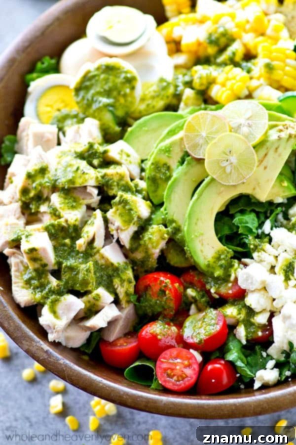 Vibrant Green Goddess Cobb 5 A bowl of the homemade Basil Green Goddess Dressing, showcasing its smooth, creamy, and vibrant green texture, ready to be poured over the salad.