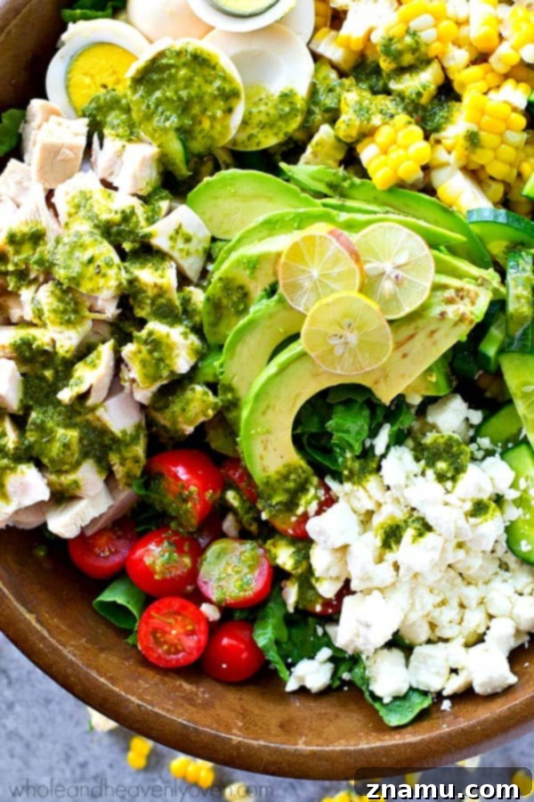 Vibrant Green Goddess Cobb 6 A large salad bowl filled with the colorful ingredients of the Green Goddess Summer Cobb Salad, artfully arranged before the dressing is added.