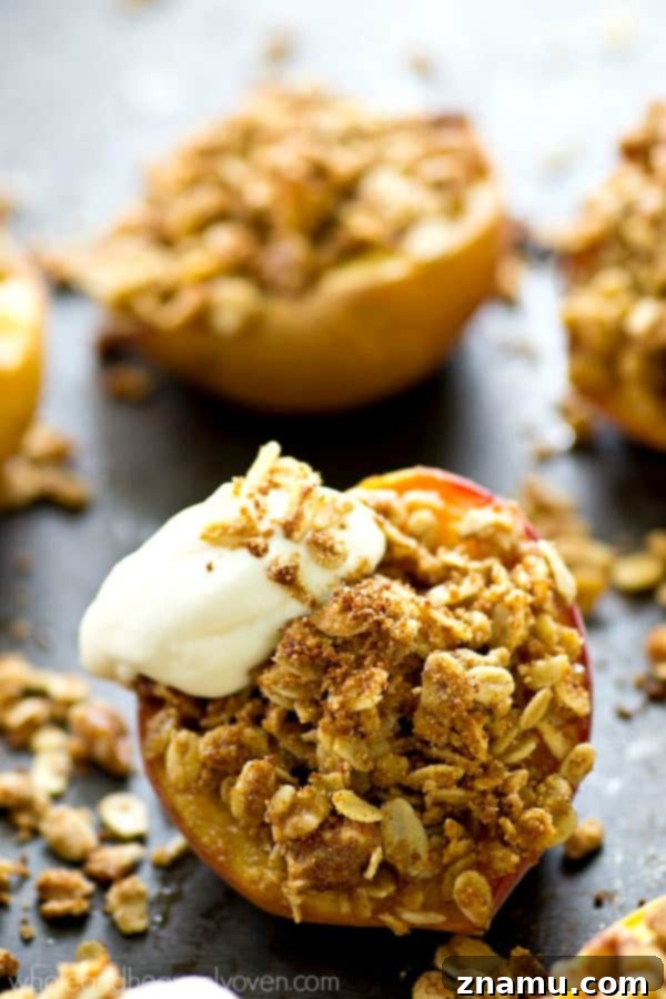 Golden Baked Peaches with a Sweet Pecan-Oat Crumble 7 A delightful close-up of a baked peach half generously topped with a swirl of fresh whipped cream and a dusting of cinnamon.