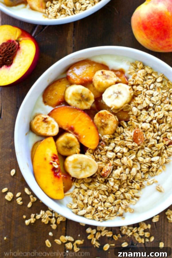 Close-up shot of a granola yogurt bowl with fresh and caramelized fruit, highlighting its appealing textures.