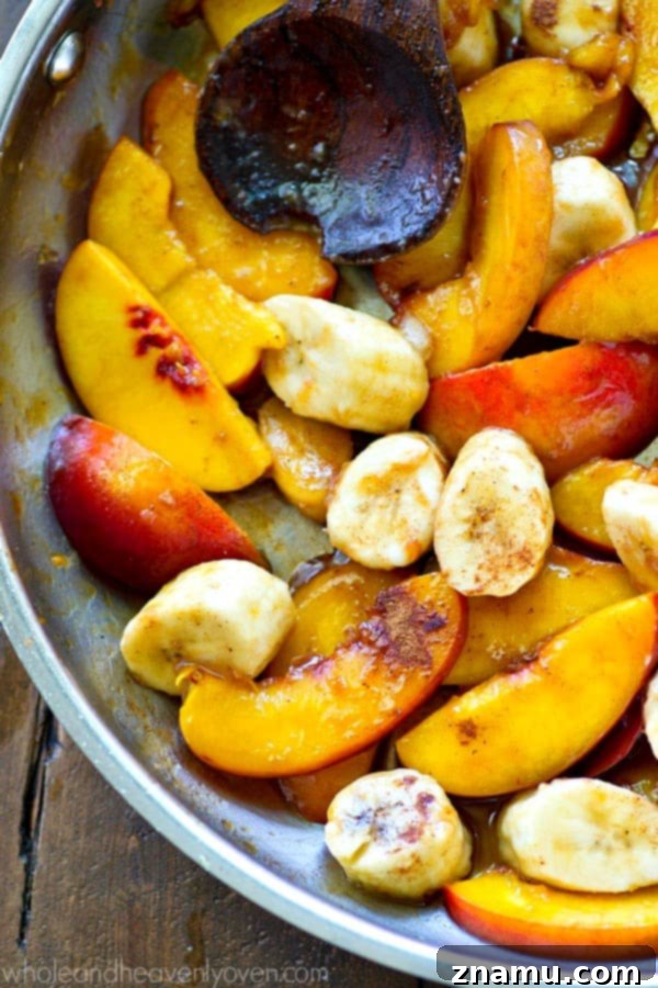 A pan filled with freshly caramelized banana and peach slices, ready to be added to yogurt bowls.