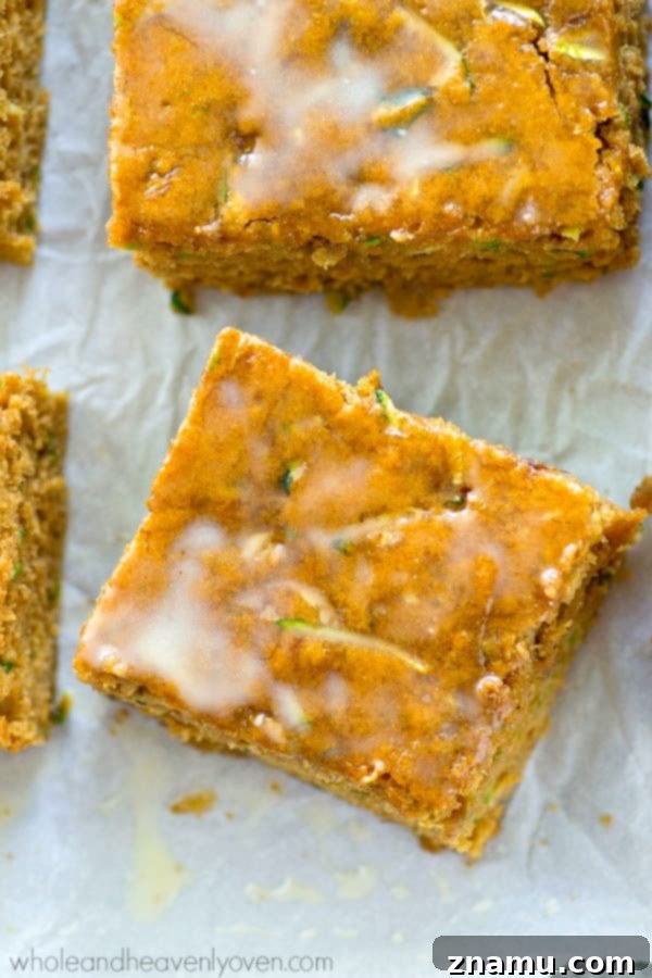 Moist Zucchini Sheet Cake with Tropical Pineapple Glaze 4 A slice of moist zucchini sheet cake being generously drizzled with a rich, yellow pineapple glaze, highlighting its tempting appearance.