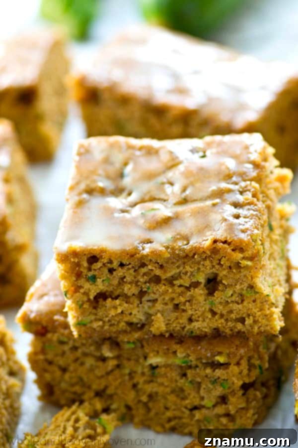 Moist Zucchini Sheet Cake with Tropical Pineapple Glaze 6 A large zucchini sheet cake, partially sliced, showing the fluffy interior texture of the cake and the smooth, glossy pineapple glaze.