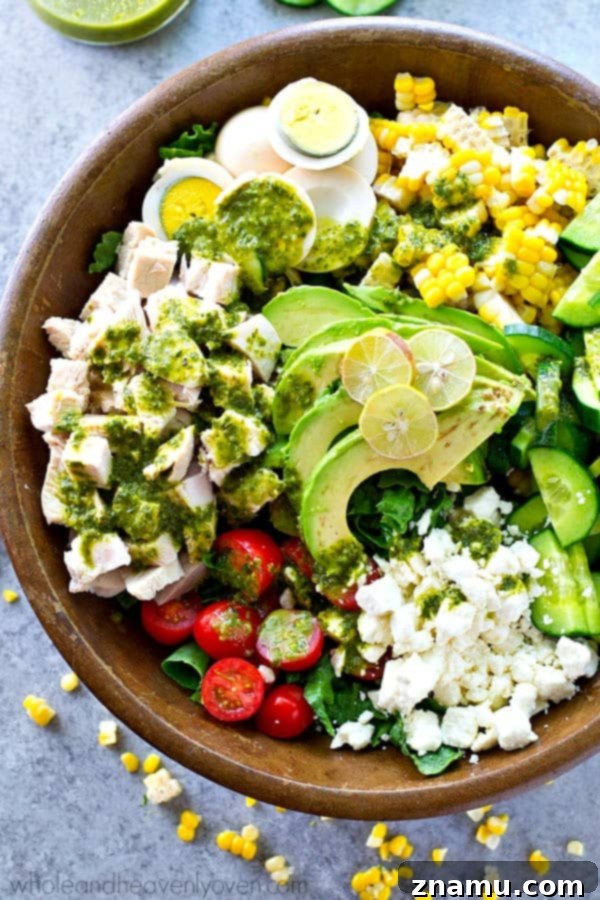 Grilled Summer Panzanella 10 A beautifully arranged Green Goddess Summer Cobb Salad in a white bowl, featuring hard-boiled eggs, bacon, corn, cherry tomatoes, avocado, and a generous drizzle of vibrant green goddess dressing, served with crisp romaine lettuce.