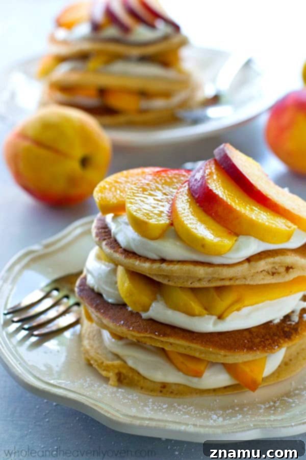 Peaches 'n' Cream Cheesecake Pancake Stacks 5 A top-down view of Peaches 'n' Cream Cheesecake Pancake Stacks, showcasing perfectly cooked pancakes, thick cream cheese, and vibrant peach slices.