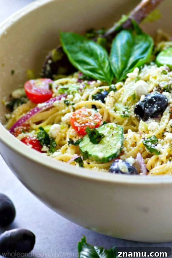 Mediterranean Spaghetti Toss with Zesty Dijon-Parmesan 3 Close-up of a large bowl of Greek Spaghetti Pasta Salad, showcasing the diverse ingredients and rich textures.