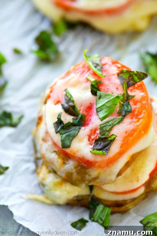 Caprese Towers with Heirloom Tomatoes and Eggplant 6 A serving of three eggplant Caprese stacks on a plate, showcasing the distinct layers and melted cheese, ready to be enjoyed as a gourmet appetizer.