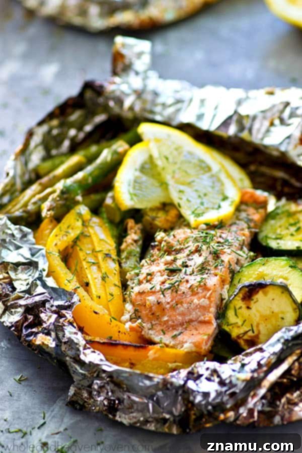 Close-up of a fork piercing a piece of perfectly cooked, flaky salmon from an open foil packet, showcasing its tender texture and delicious grilled vegetables. The meal is ready to be savored.
