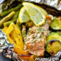 Perfectly grilled salmon and tender vegetables infused with a zesty lemon-dill marinade, cooked in convenient foil packets. An ideal meal for quick summer dinners.
