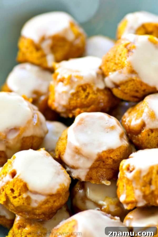 Lighter Pumpkin Spice Glaze Poppers 6 A hand holding a perfectly glazed pumpkin spice donut hole.