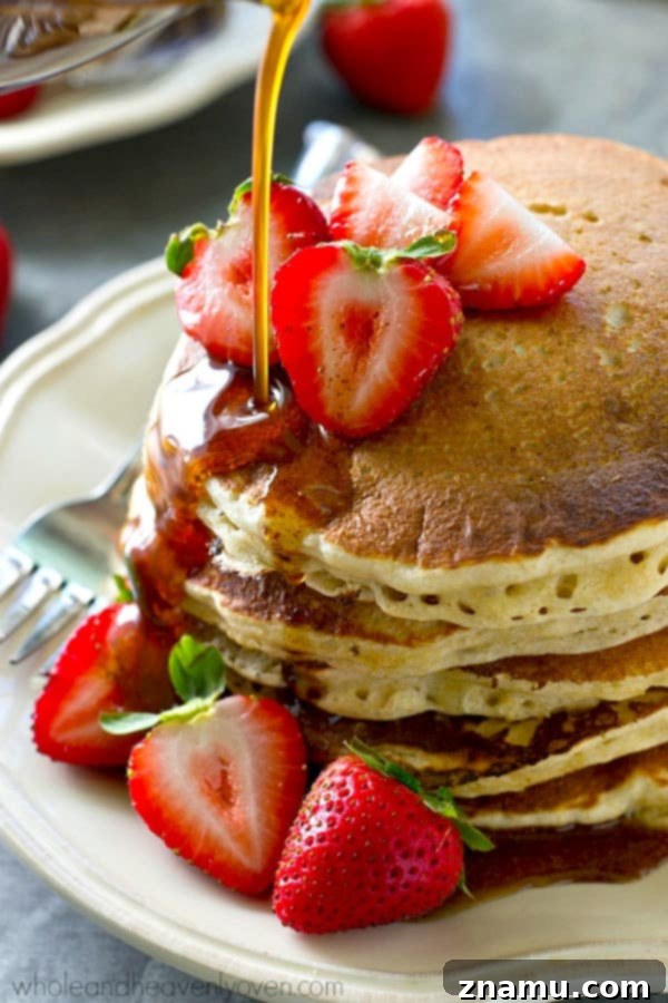 Chai Maple Drizzled Protein Power Pancakes 5 A stack of perfectly cooked protein power pancakes, showcasing their thick and airy texture, drizzled with warm chai maple syrup.