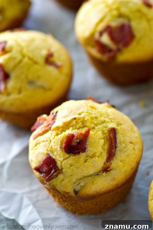 Brown Butter Bacon Cornbread Muffins 4 Warm cornbread muffins filled with bacon and browned butter, cooling on a rack, ready for a sweet honey drizzle.