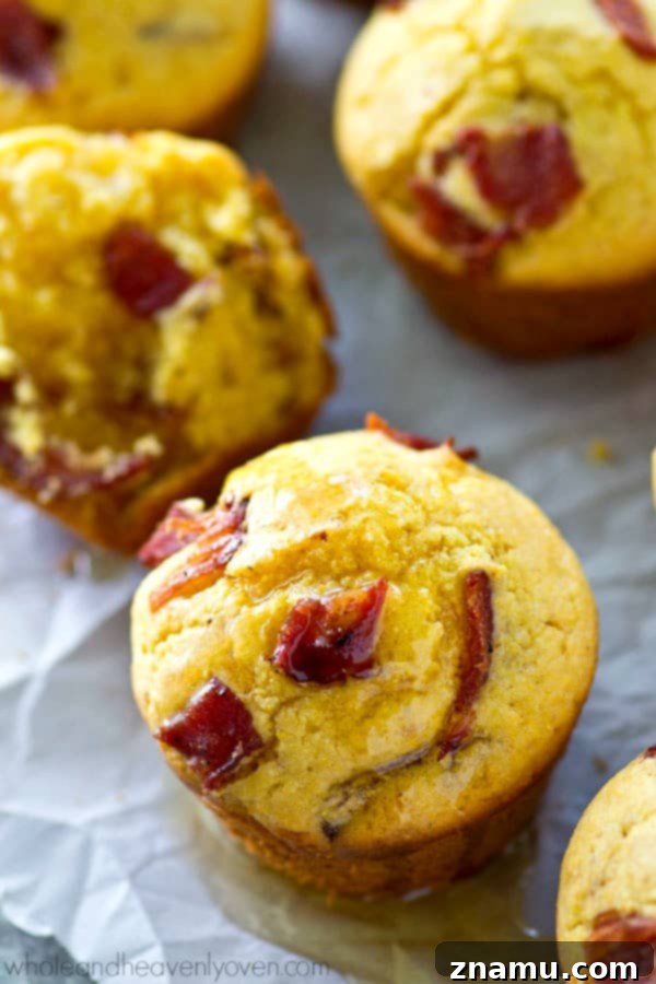 Brown Butter Bacon Cornbread Muffins 6 Close-up of a warm, golden cornbread muffin with a generous drizzle of honey melting into its soft texture.