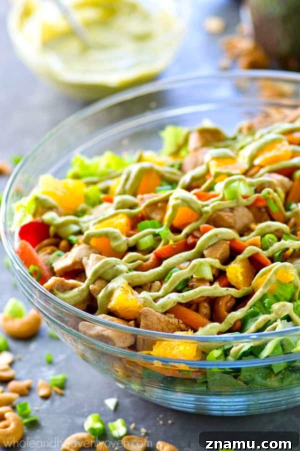 Creamy Chipotle Avocado Cashew Chicken Salad 3 A close-up shot of the cashew chicken salad, showing fresh greens, orange segments, and tender chicken with cashews, ready for dressing.