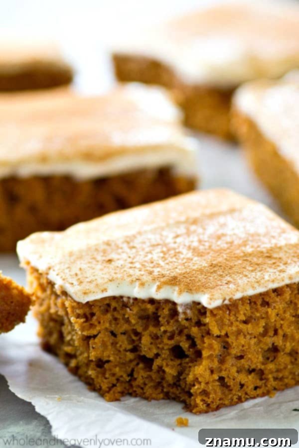 Spiced Applesauce Snack Cake with Cream Cheese Frosting 4 Applesauce snack cake slices on a serving platter, showing moist texture