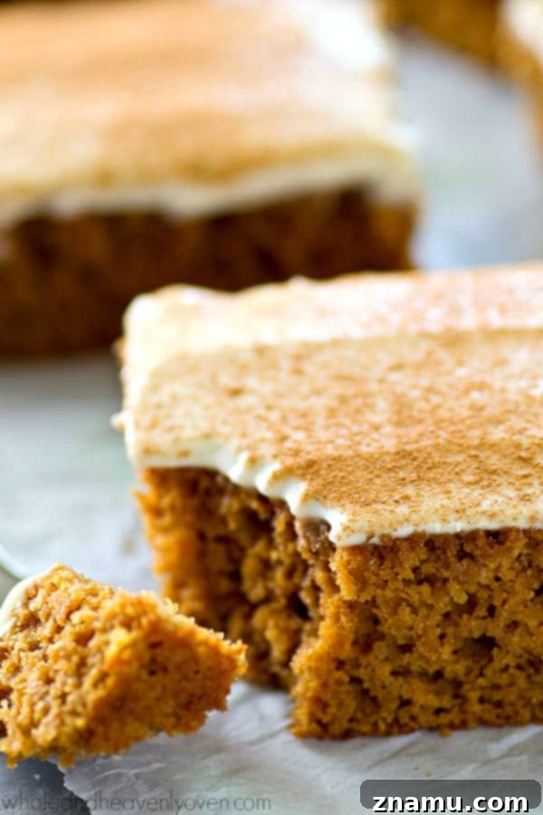 Spiced Applesauce Snack Cake with Cream Cheese Frosting 7 Stack of applesauce snack cake squares on a white plate with frosting visible