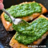 Simple pan-seared salmon is smothered in a flavorful spinach basil pesto sauce for a healthier dinner you can have ready in under 15 minutes. Serve this salmon with a green salad and you've got dinner done!