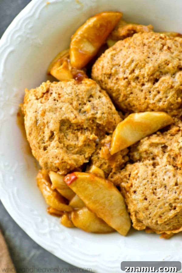Brown Butter Biscuit Apple Cobbler 3 Close-up of baked apple cobbler, showing the golden-brown biscuit topping and bubbling apple filling.