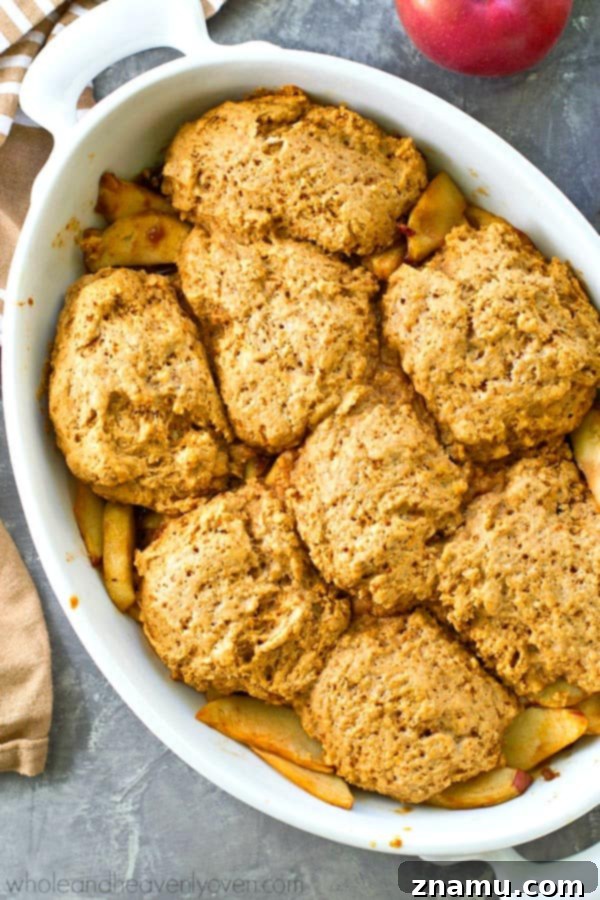 Brown Butter Biscuit Apple Cobbler 6 A slice of apple cobbler with browned butter biscuits, served with a fork.