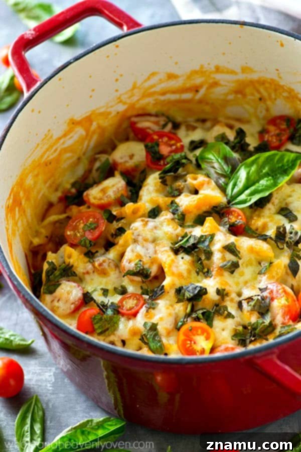 Basil Sausage Caprese Skillet Pasta 4 Overhead shot of a deep skillet filled with bubbling one-pot caprese pasta, cooked to perfection and ready for the final touches.