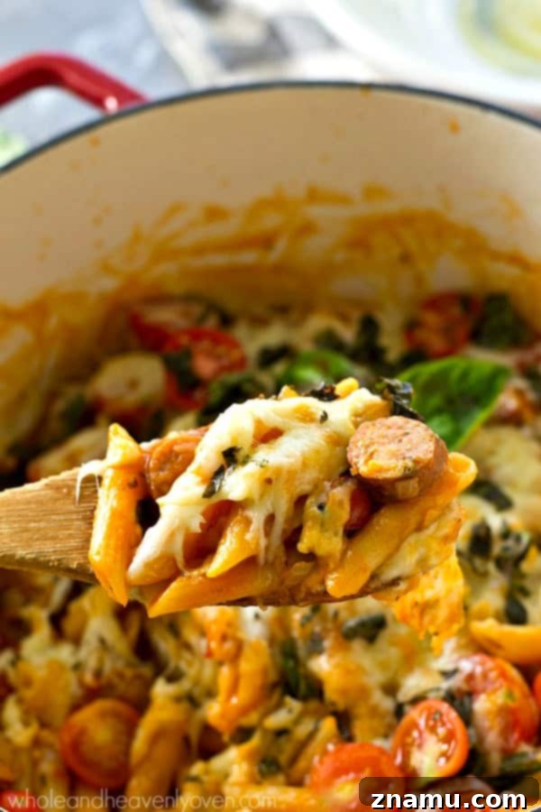 Basil Sausage Caprese Skillet Pasta 6 A large pot of one-pot caprese pasta simmering on the stove, with pasta, sausage, and sauce cooking together.