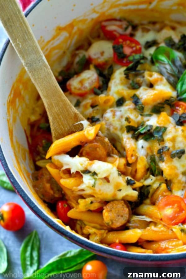 Basil Sausage Caprese Skillet Pasta 7 A close-up shot of the finished one-pot caprese pasta, garnished with fresh basil, showing the melted mozzarella and tender pasta.