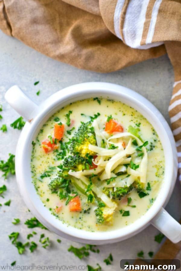 Wholesome Slow Cooker Broccoli Cheddar Soup 6 A spoon scooping a generous portion of rich, melted cheddar cheese into the simmering broccoli cheese soup.