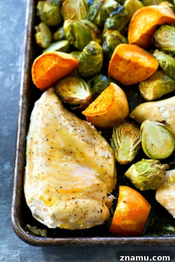 Juicy maple chicken, and tender sweet potatoes and brussels sprouts are are all roasted to perfection in ONE pan in less than an hour for an easy weeknight dinner with ZERO work involved!