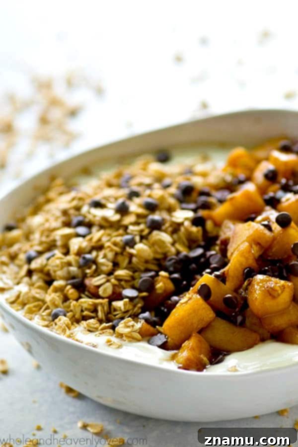 Caramel Apple Pie Flavored Granola Yogurt Bowls 3 Close-up shot of a Caramel Apple Pie Granola Yogurt Bowl, highlighting the texture of the granola and the rich caramel sauce on the apples.