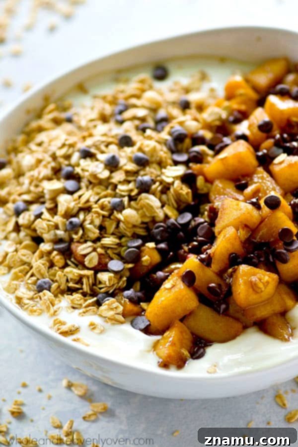 Caramel Apple Pie Flavored Granola Yogurt Bowls 4 Overhead view of a Caramel Apple Pie Granola Yogurt Bowl, showing the vibrant colors of the apples, white yogurt, and golden granola.