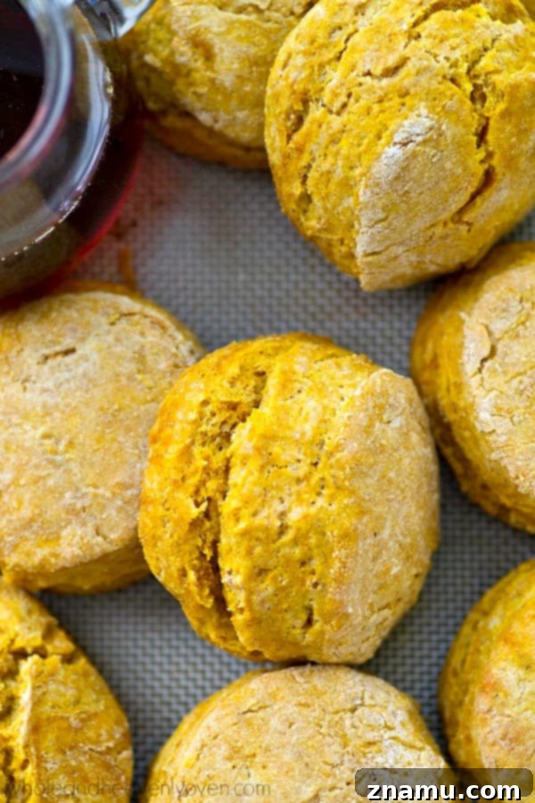 Cozy Maple Pumpkin Spice Biscuits 7 A stack of perfectly baked maple pumpkin spice biscuits on a wooden cutting board, ready to be served.