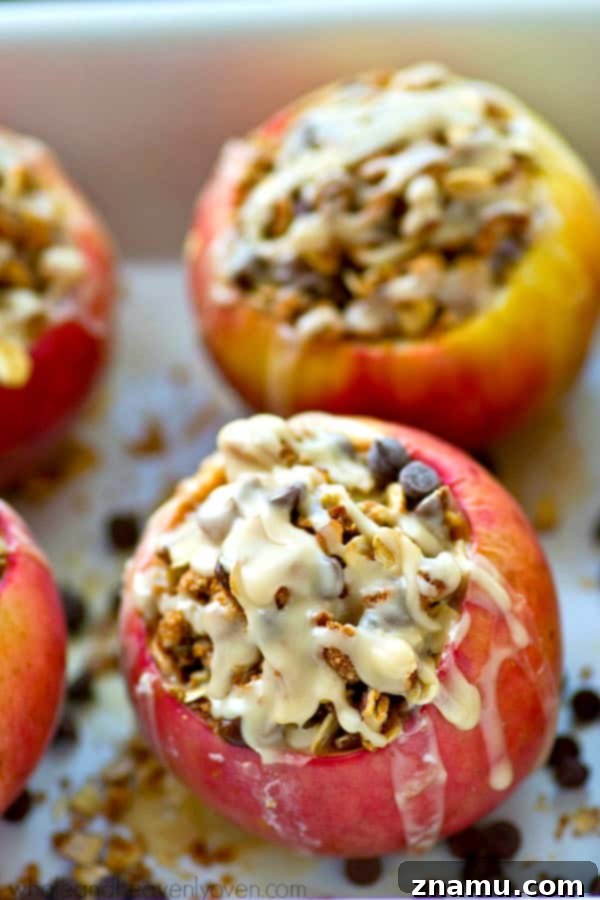 Chocolate Chip Iced Oatmeal Baked Apples 3 Close-up of a warm baked apple, brimming with oatmeal chocolate chip cookie filling and melted chocolate.