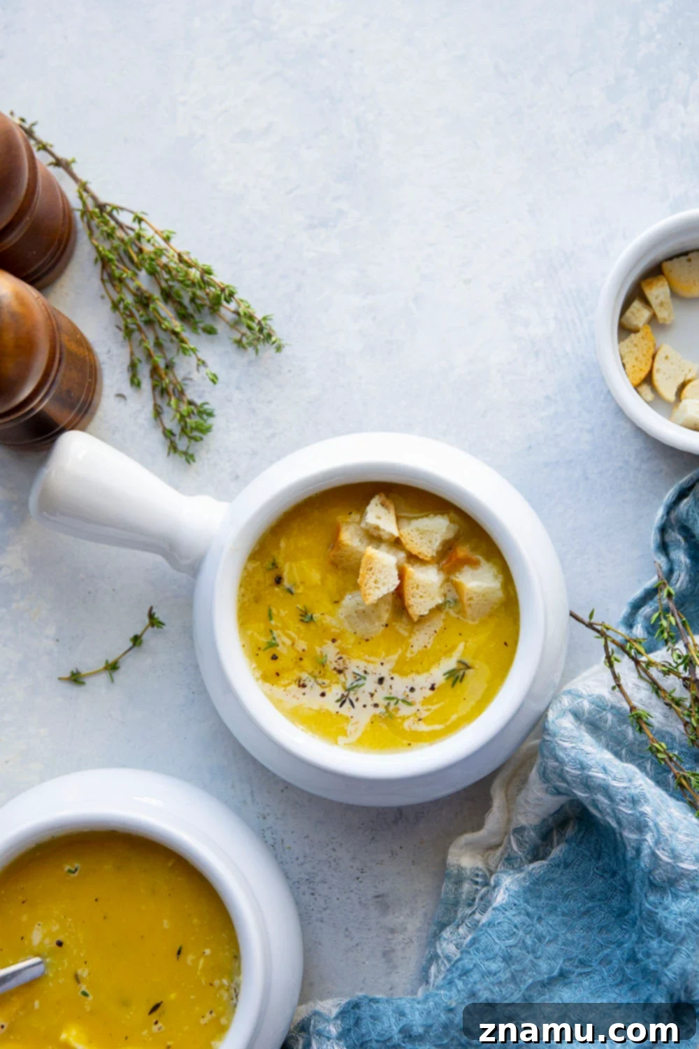 Creamy Crockpot Butternut Squash Soup 3 Close-up of creamy butternut squash soup in a bowl, with golden croutons and a delicate cream swirl on top, emphasizing its smooth texture.
