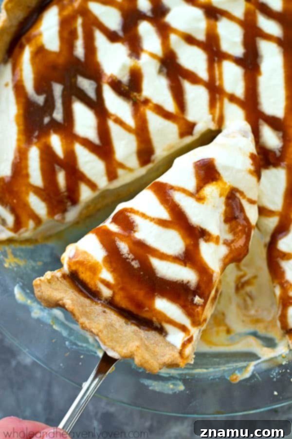 Decadent No-Bake Caramel Pumpkin Cheesecake 6 A large slice of No-Bake Caramel Cheesecake Pumpkin Pie served on a plate, garnished with whipped cream and caramel