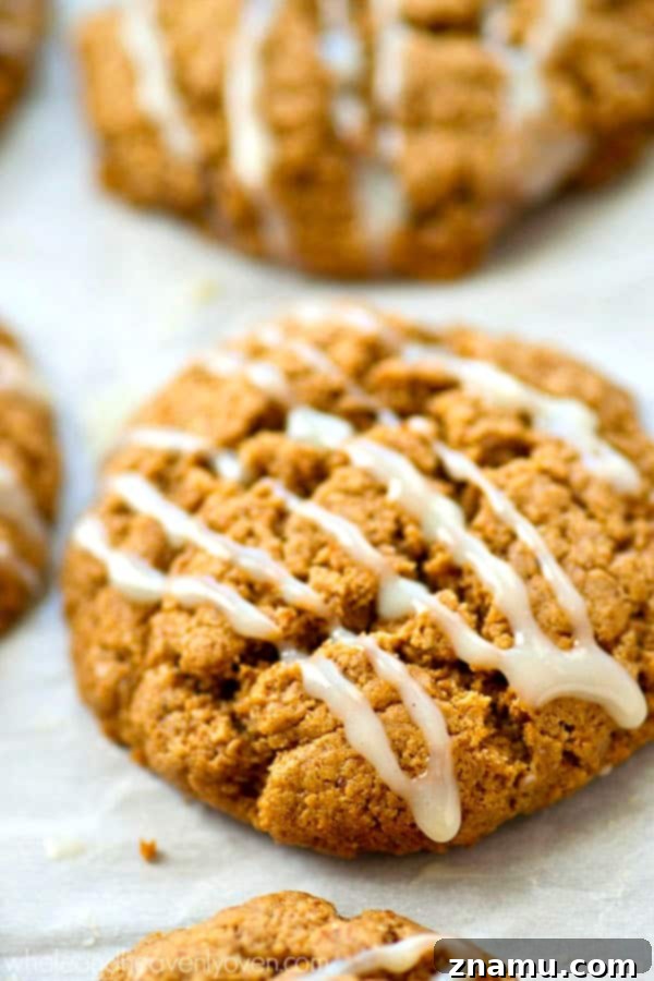 A close-up of a stack of flourless white chocolate gingersnaps, showing their tender interior and generous white chocolate topping.