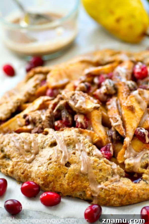 Close-up of a pear and cranberry galette before baking, showcasing the vibrant fruit filling.