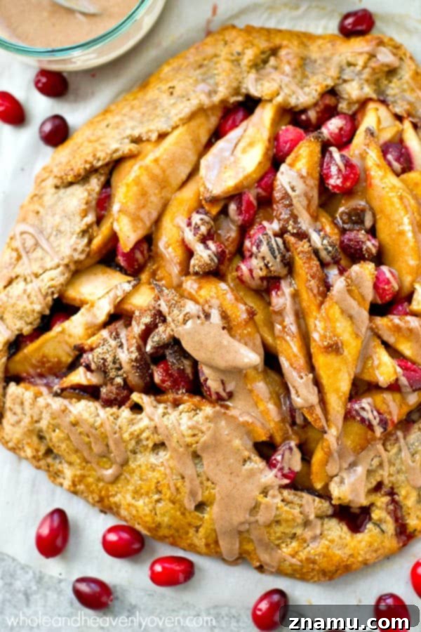 Homemade galette crust being folded over a sweet pear and cranberry filling.