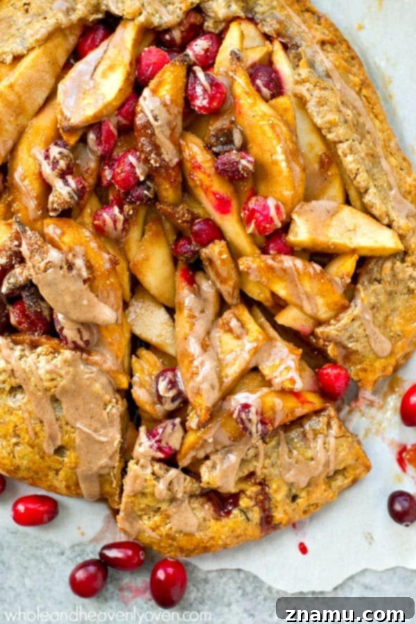 Delicious chai spice glaze being drizzled generously over a warm pear cranberry galette.