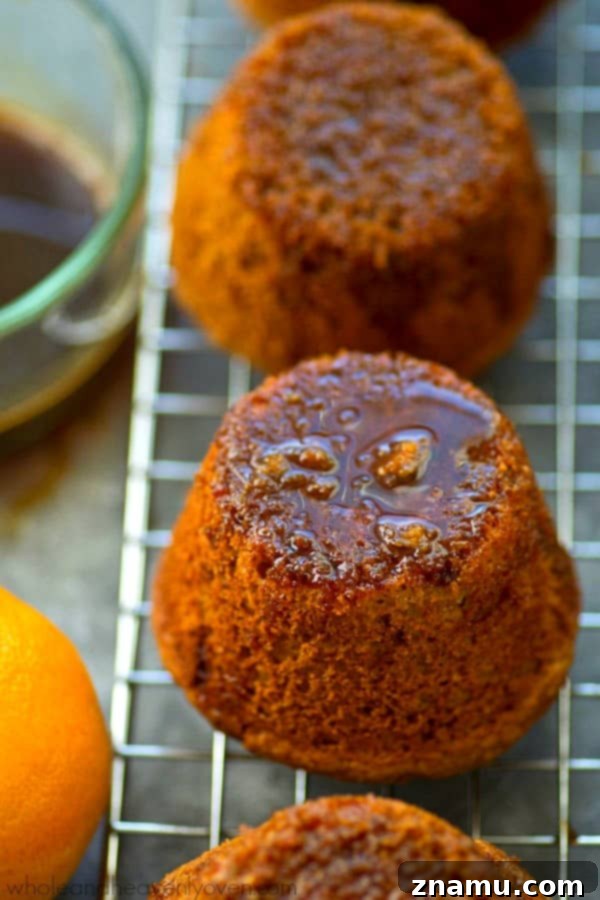 Zingy Sticky Orange Gingerbread Muffins 3 A close-up of a warm gingerbread muffin, showcasing its moist texture and delicious orange glaze.