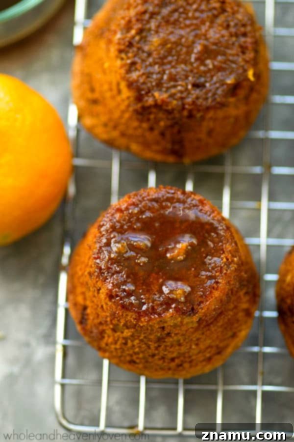 Zingy Sticky Orange Gingerbread Muffins 4 A batch of golden-brown gingerbread muffins, cooling on a wire rack, ready for glazing.