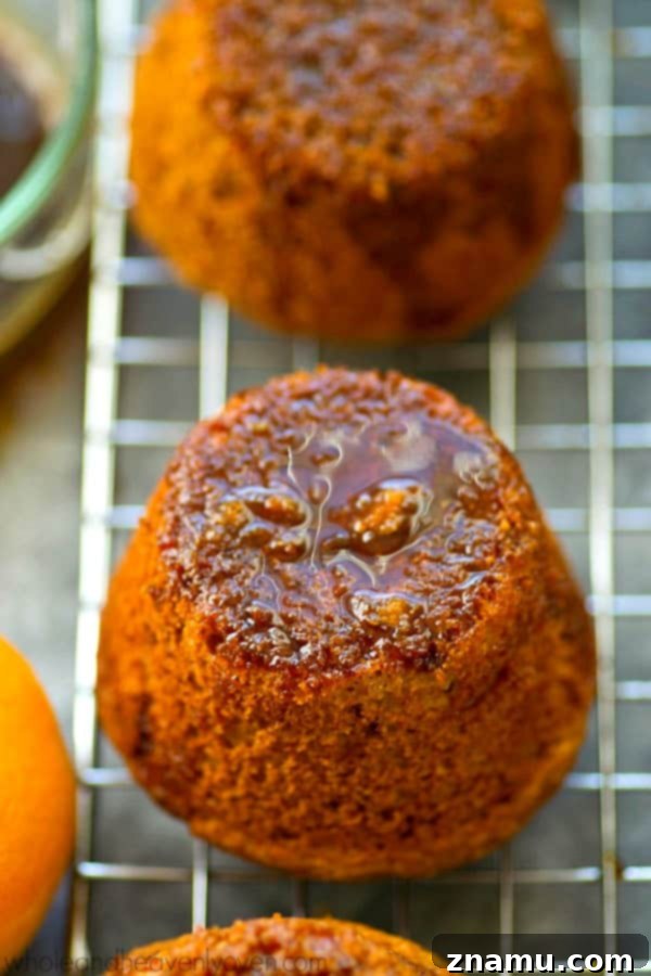 Zingy Sticky Orange Gingerbread Muffins 7 A single gingerbread muffin, perfectly glazed, with crumbs showing its soft interior.