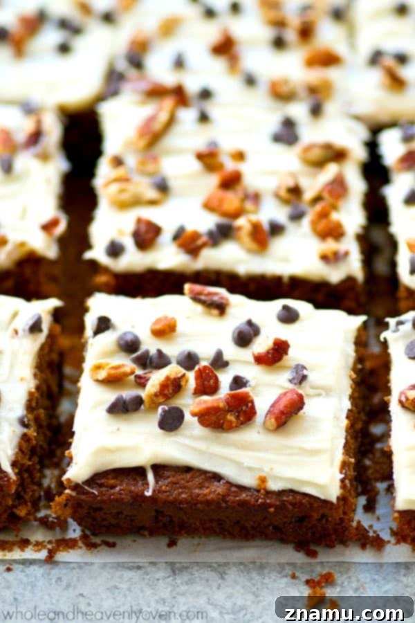 A stack of gingerbread cake bars with cream cheese frosting, ready to be enjoyed as a festive dessert.