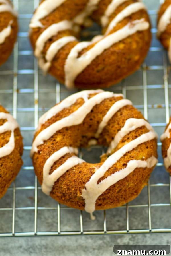 Close-up of baked banana bread donuts with a generous drizzle of chai glaze.
