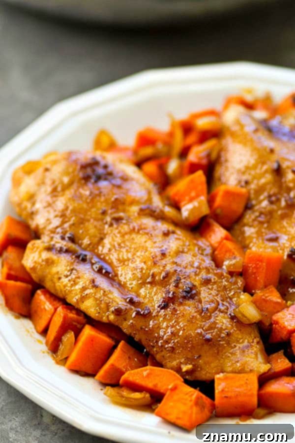 Sticky Maple Chicken & Sweet Potato Hash 3 Close-up of golden-brown maple glazed chicken breasts and caramelized sweet potatoes in a cast iron skillet.