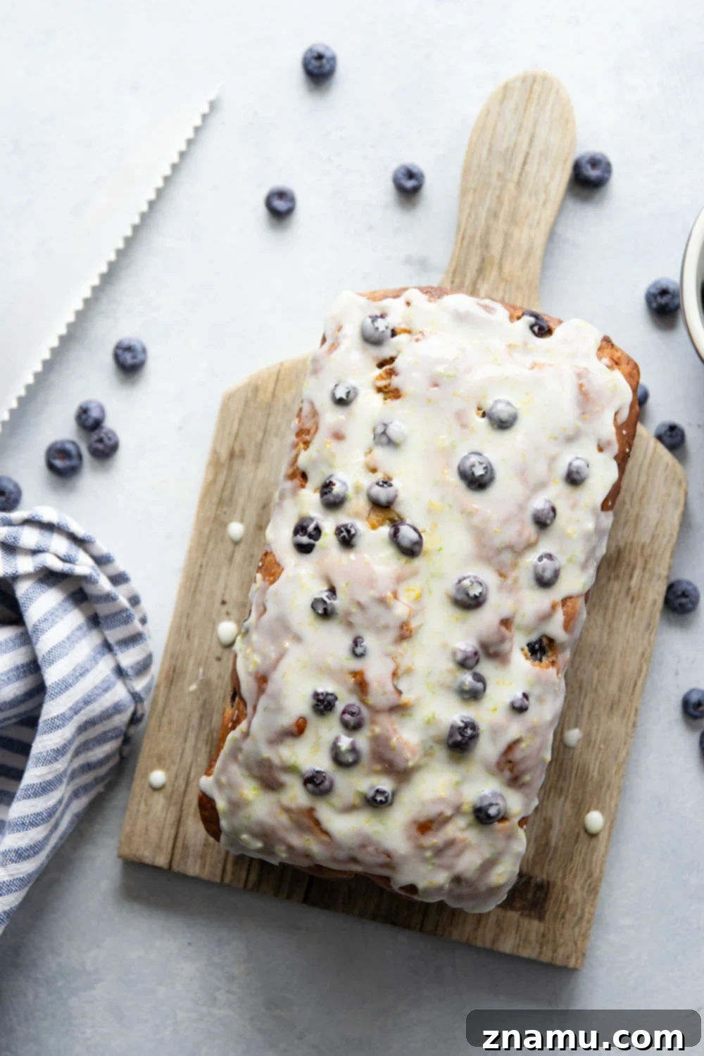 Sunshine Blueberry Banana Bread with Zesty Citrus Glaze 4 Close-up of blueberry banana bread with citrus glaze drizzling