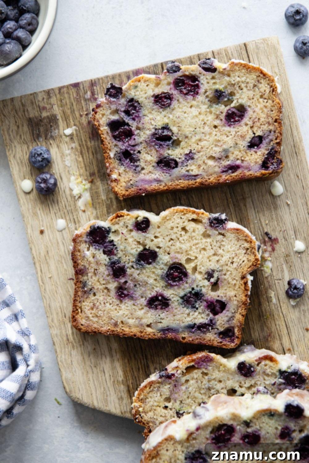 Sunshine Blueberry Banana Bread with Zesty Citrus Glaze 6 Two slices of blueberry banana bread with citrus glaze on a plate