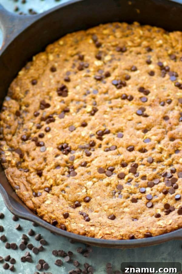 Hindistan Cevizi Yağı, Yulaf ve Damla Çikolatalı Tava Kurabiyesi 3 Close-up of a warm, gooey oatmeal chocolate chip skillet cookie, made without butter and ready to be enjoyed directly from the pan.