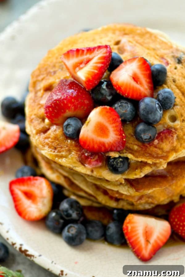 Hearty Berry Multi-Grain Pancakes 3 Stack of fluffy multi-grain berry pancakes with fresh fruit and syrup